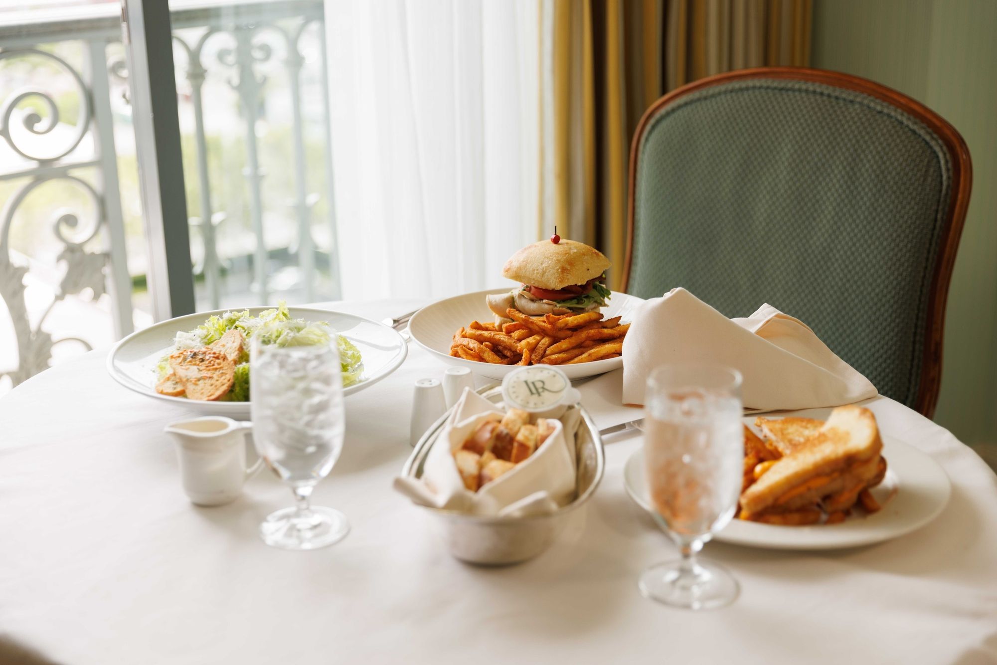Sandwiches, salad, and fresh food sit on a table in a guest room