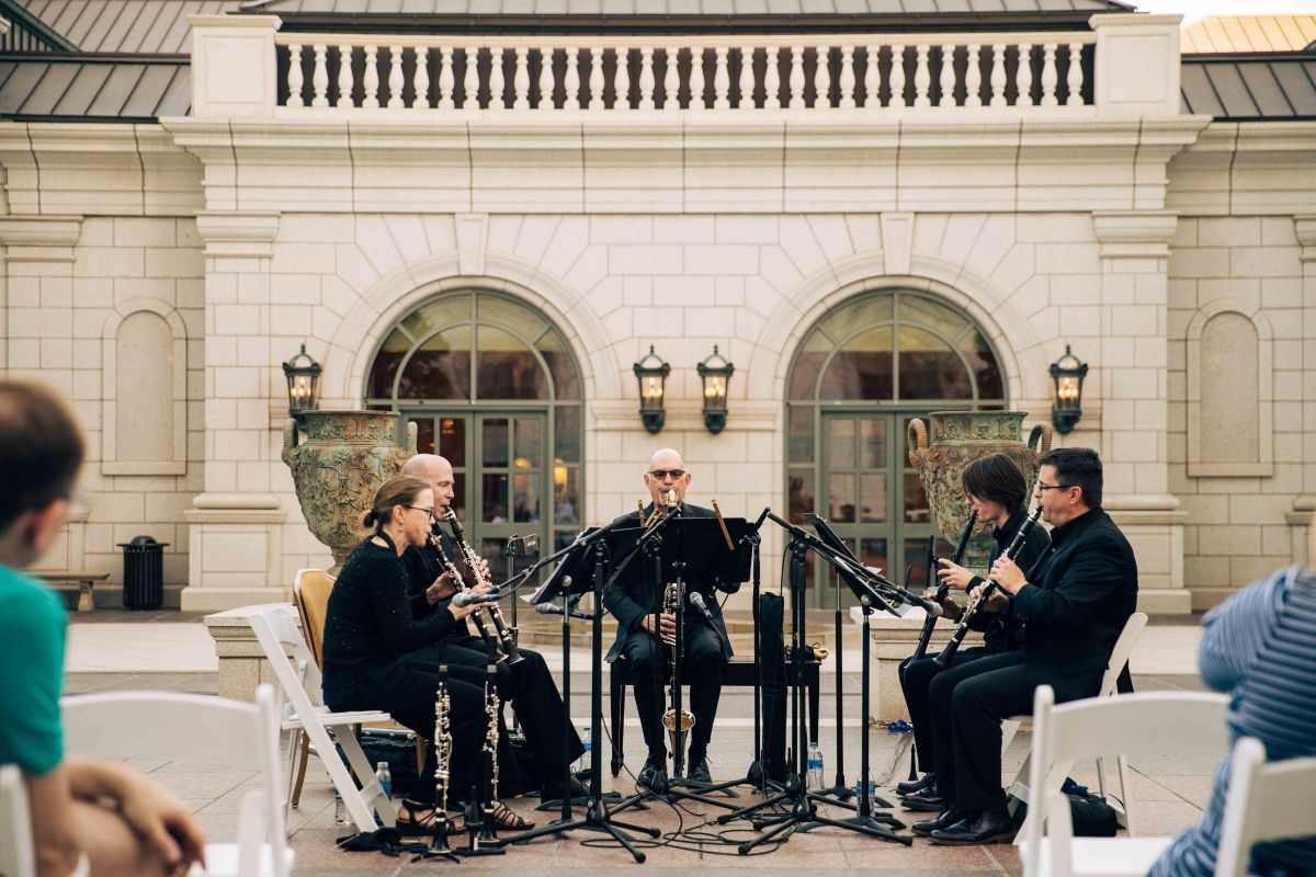 Musicians playing wind instruments for a group of people
