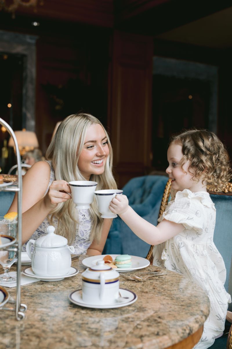 Mother and daughter enjoying tea together and doing a cheers