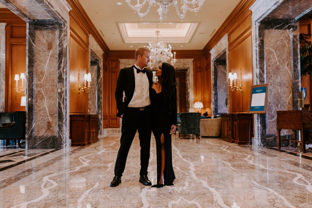 Couple standing in the hotel lobby looking at each other dressed formally