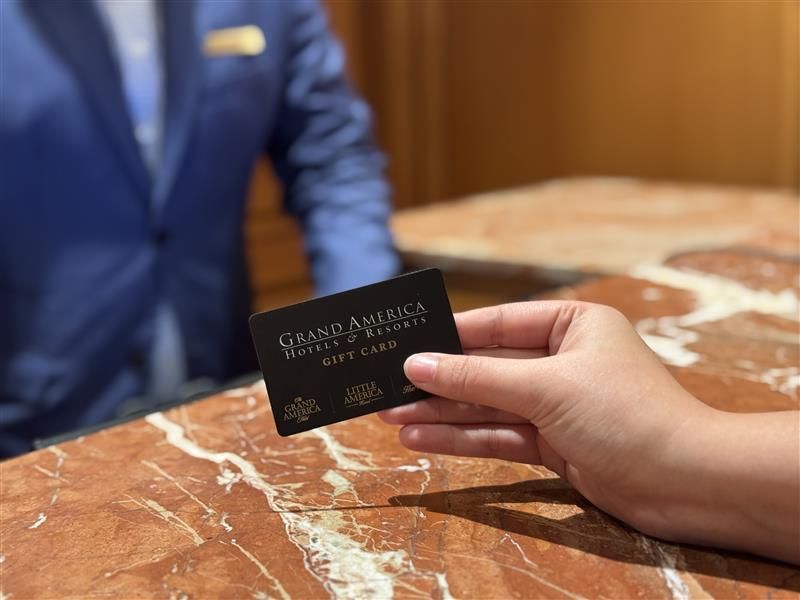 Hand holding a gift card at a reception desk