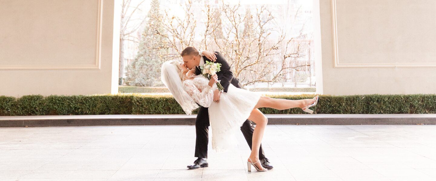 Couple kisses in porte cochere.